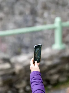 Person hält schwarzen Smartphone bei Tageslicht