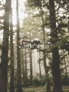 Graue DJI Mavic Pro Drohne fliegt über Wald am Tag