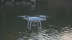 Quadcopter fliegt über Gewässer in klarem Himmel