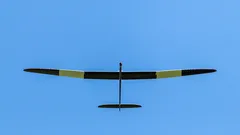 kleines Flugzeug fliegt durch blauen Himmel
