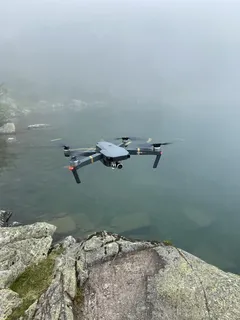 Schwarzer und roter Hubschrauber fliegt tagsüber über See in den Pyrenäen