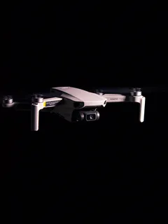 DJI Mavic Mini Drohne fliegt vor schwarzem Hintergrund
